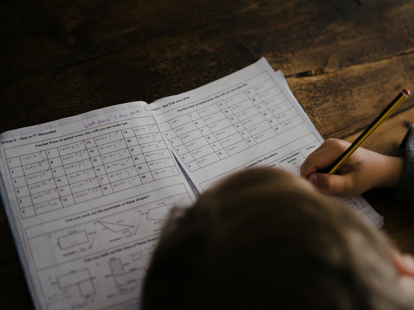 Un cahier d'exercices de multiplications annoté « Bien joué »