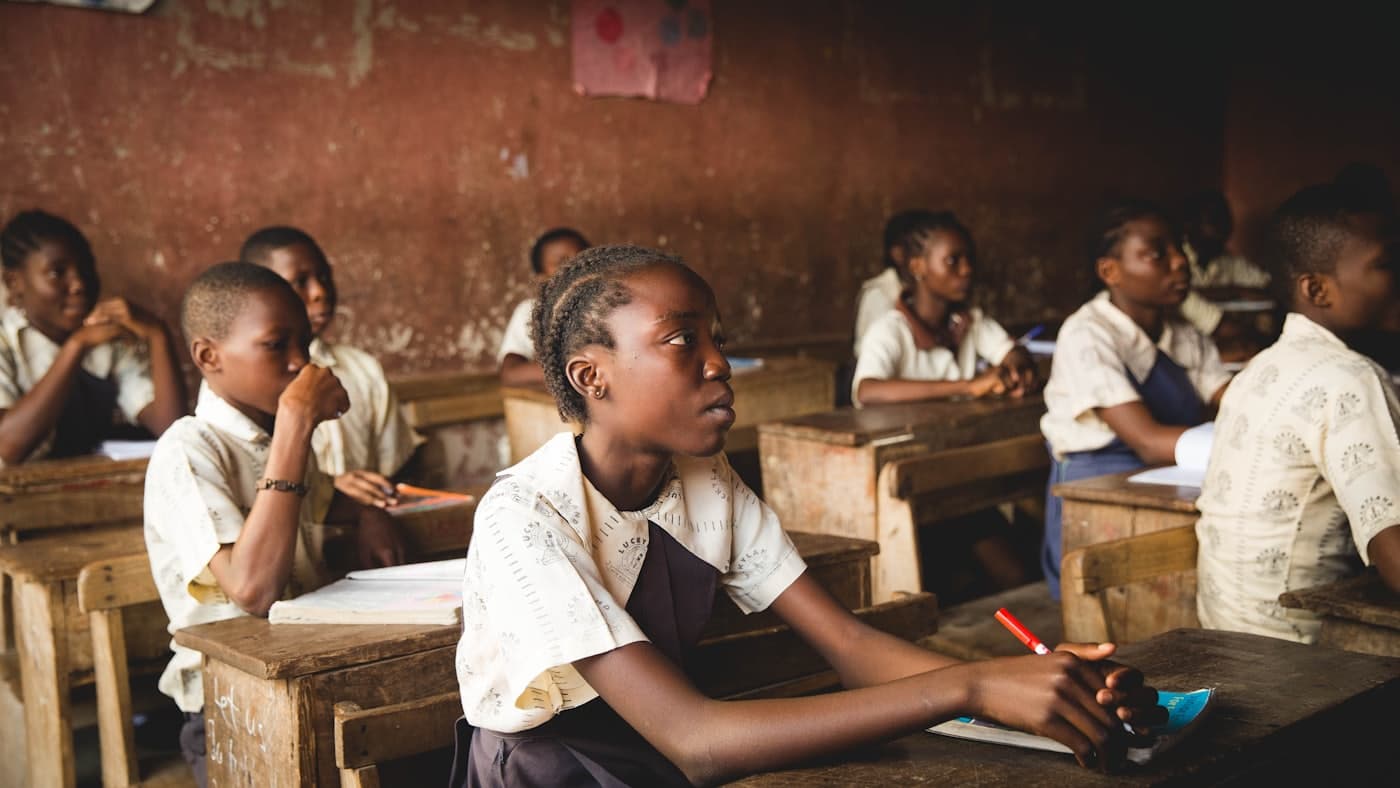Des élèves attentifs assis à leurs pupitres dans une salle de classe