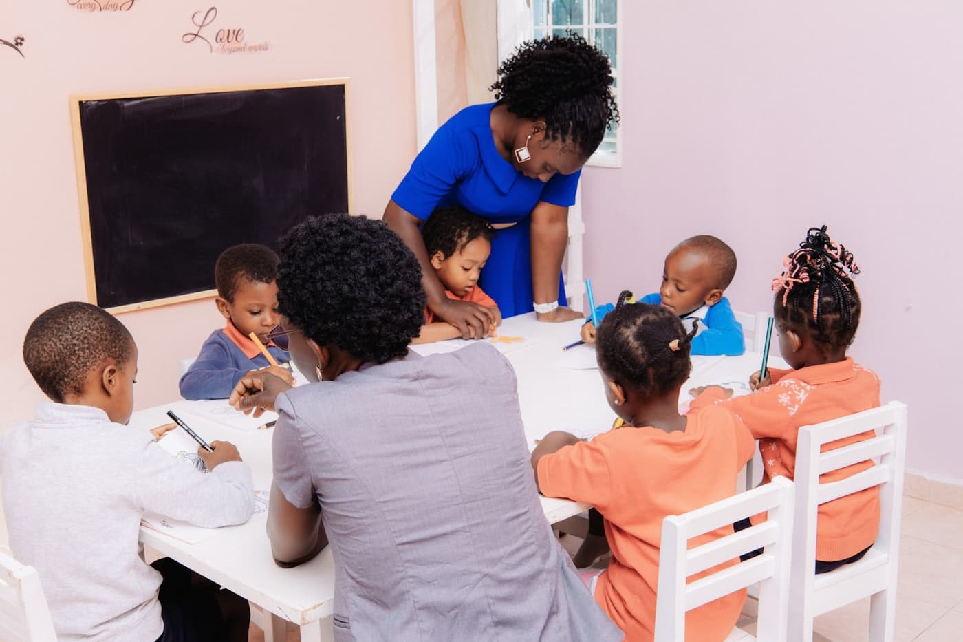 Deux enseignantes encadrent de jeunes enfants autour d'une table de travail